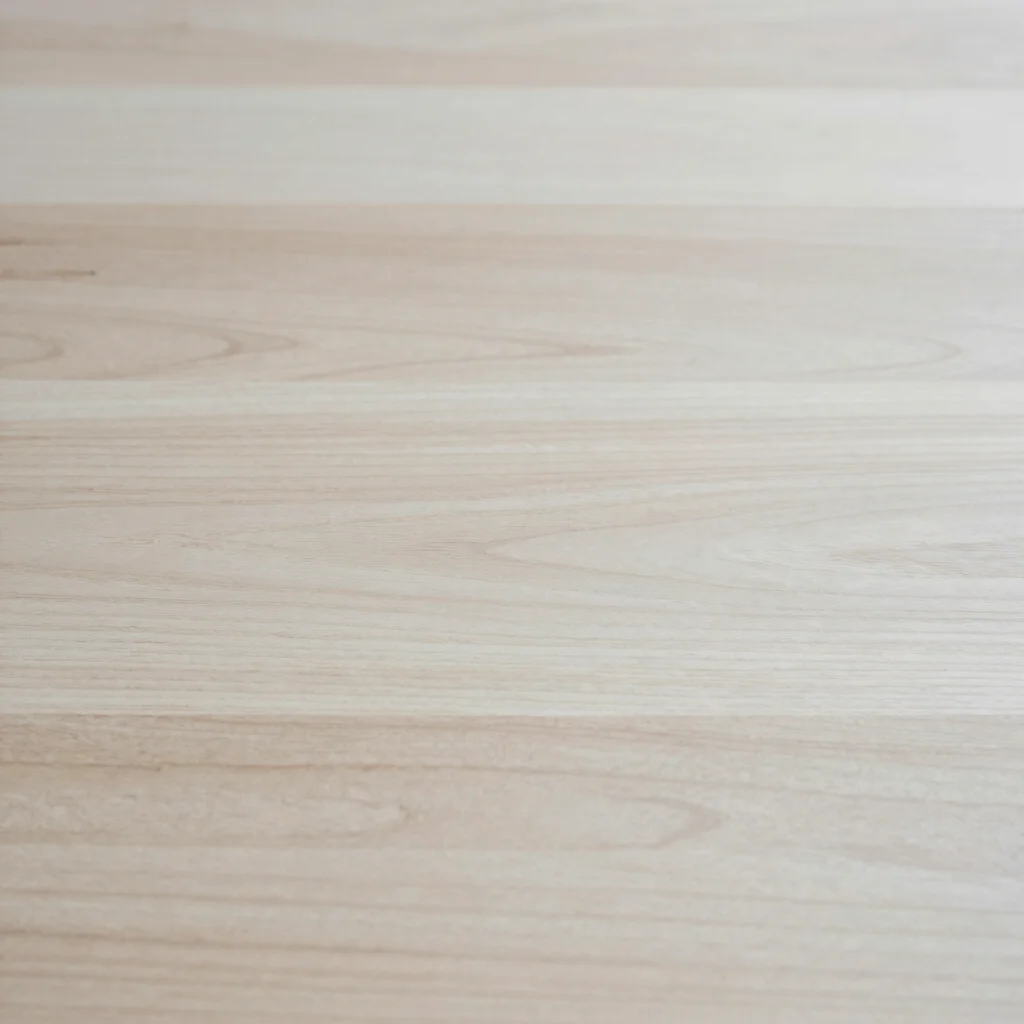 Minimal editorial still of a neutral wooden work surface with soft natural daylight, uncluttered composition, 50mm lens,